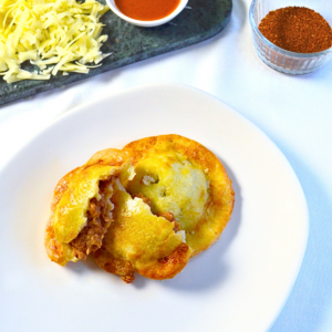 Gluten-free Pinto Bean & Cheese Empanoli—crispy, golden hand pies filled with creamy pinto beans and melted cheese, served on a white plate.
