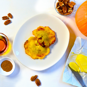 Gluten-free Pumpkin Maple Pecan Empanoli—flaky hand pies filled with spiced pumpkin, maple syrup, and toasted pecans, served on a white plate.